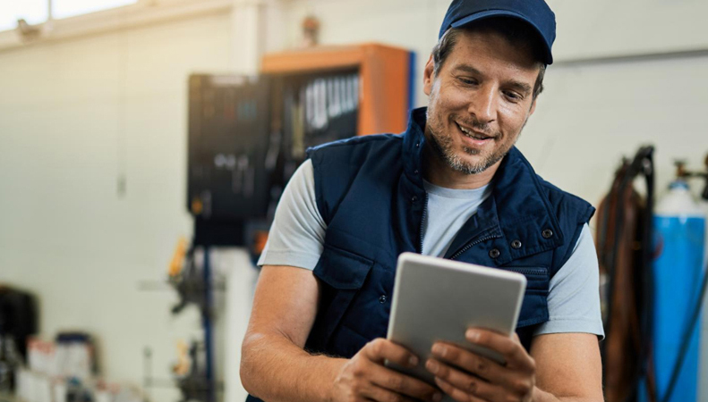 Field technician using mobile SaaS app on factory floor